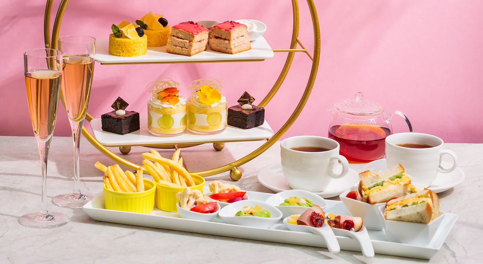 色とりどりのケーキとポットの紅茶などのアフタヌーンティーイメージ