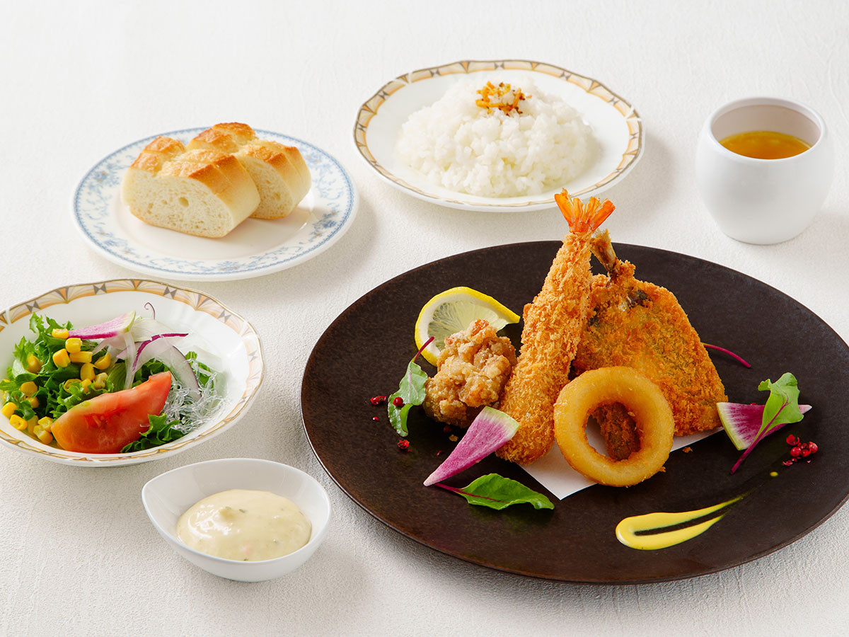 お楽しみ週替わりランチ。今週のメイン料理、サラダ、パンもしくはライス、デザートが付いたセットメニュー。