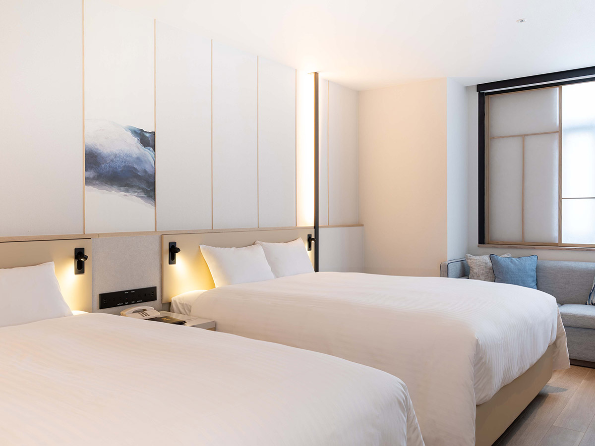 新客室エグゼクティブデラックスツインのベッドと窓とソファー