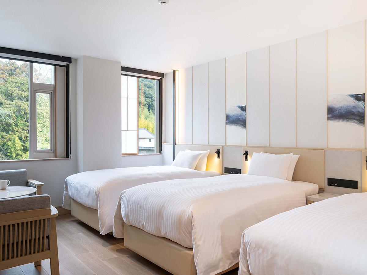 新客室トリプルルームのベッドと窓と椅子と机