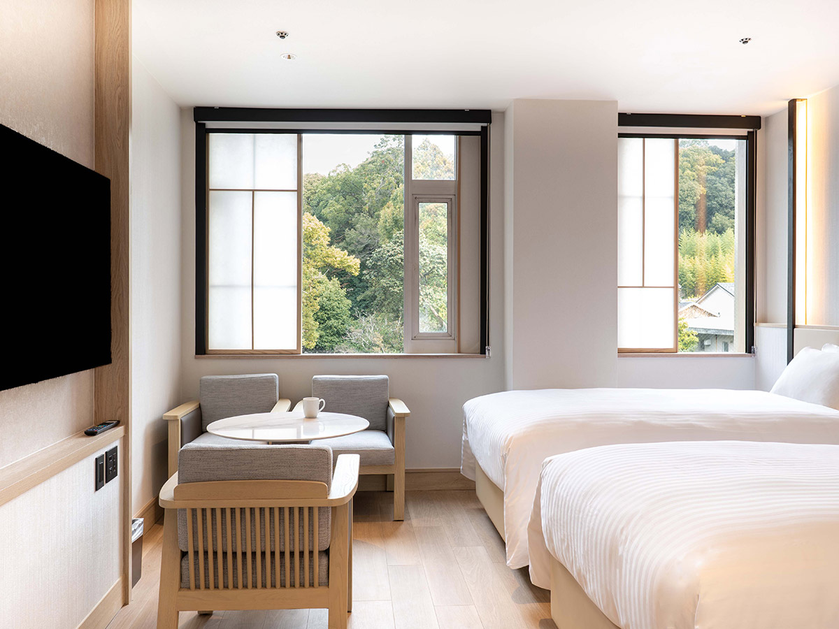 新客室トリプルルームの椅子と机と窓とテレビ