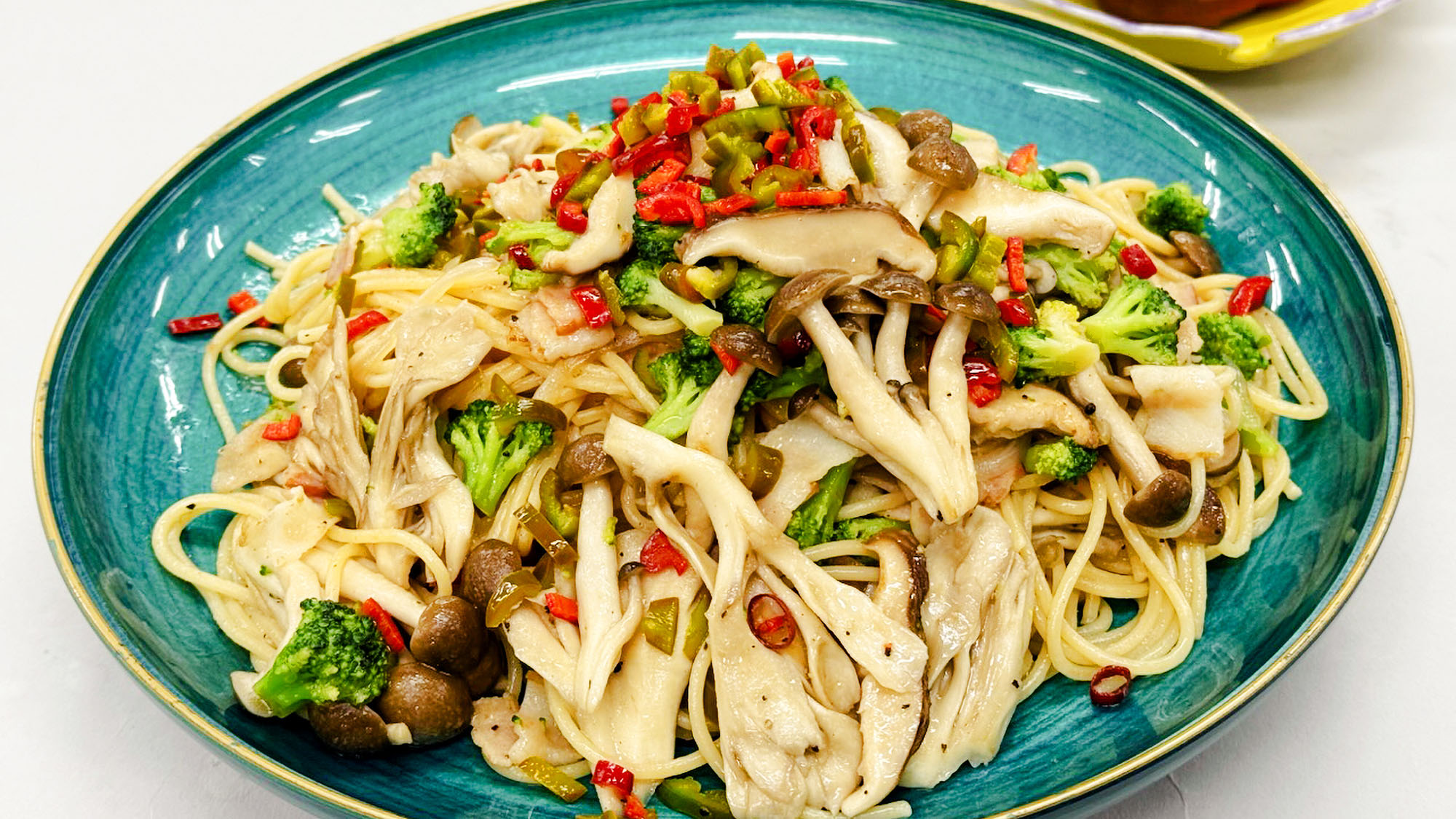 皿の上に、伊豆産きのことベーコン、にんにく、唐辛子を炒めた和風醤油パスタ。