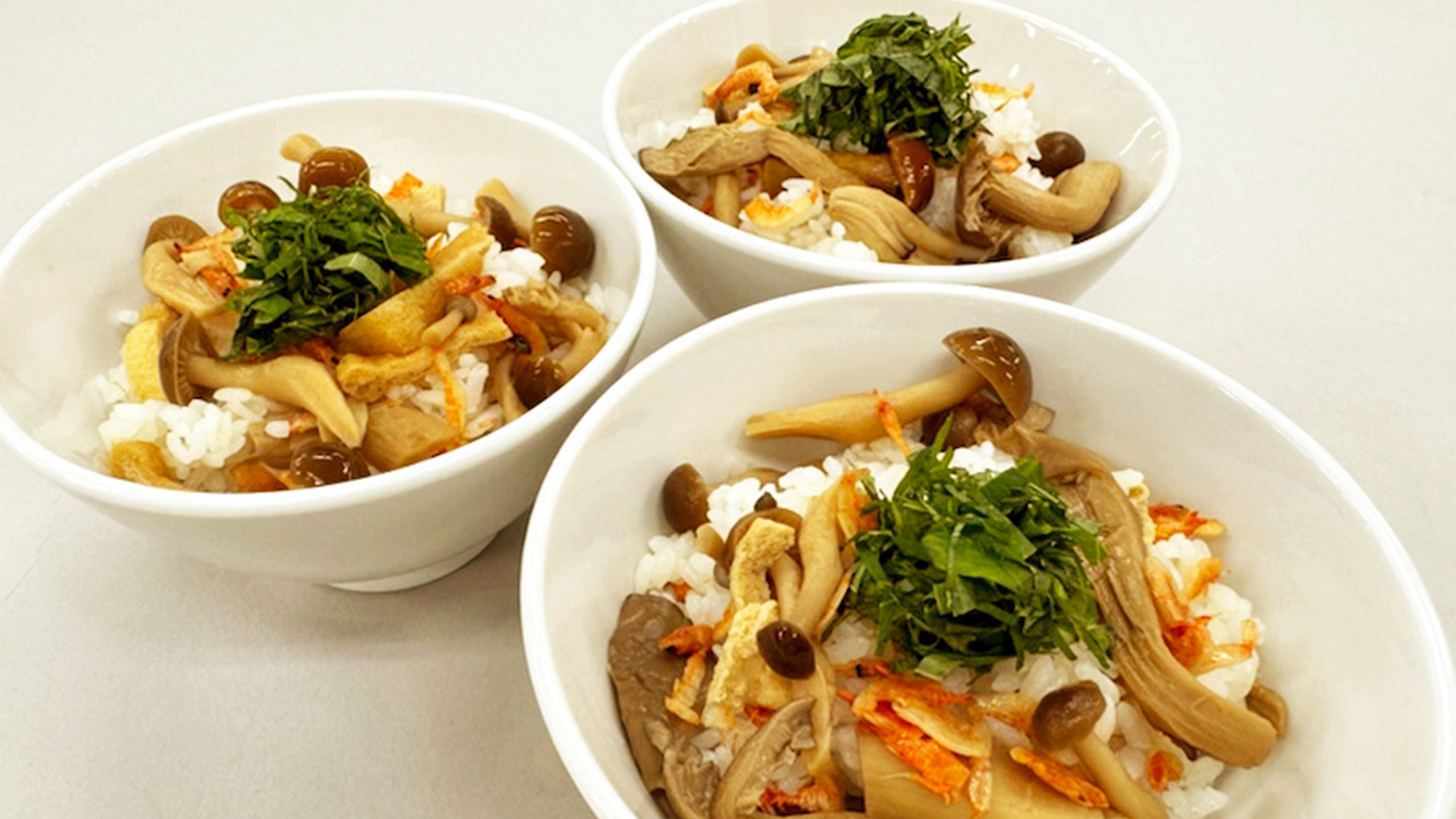 茶碗に盛られた、雑茸、しめじ、椎茸、タモギ茸、油揚げを出汁で炊き上げたご飯。