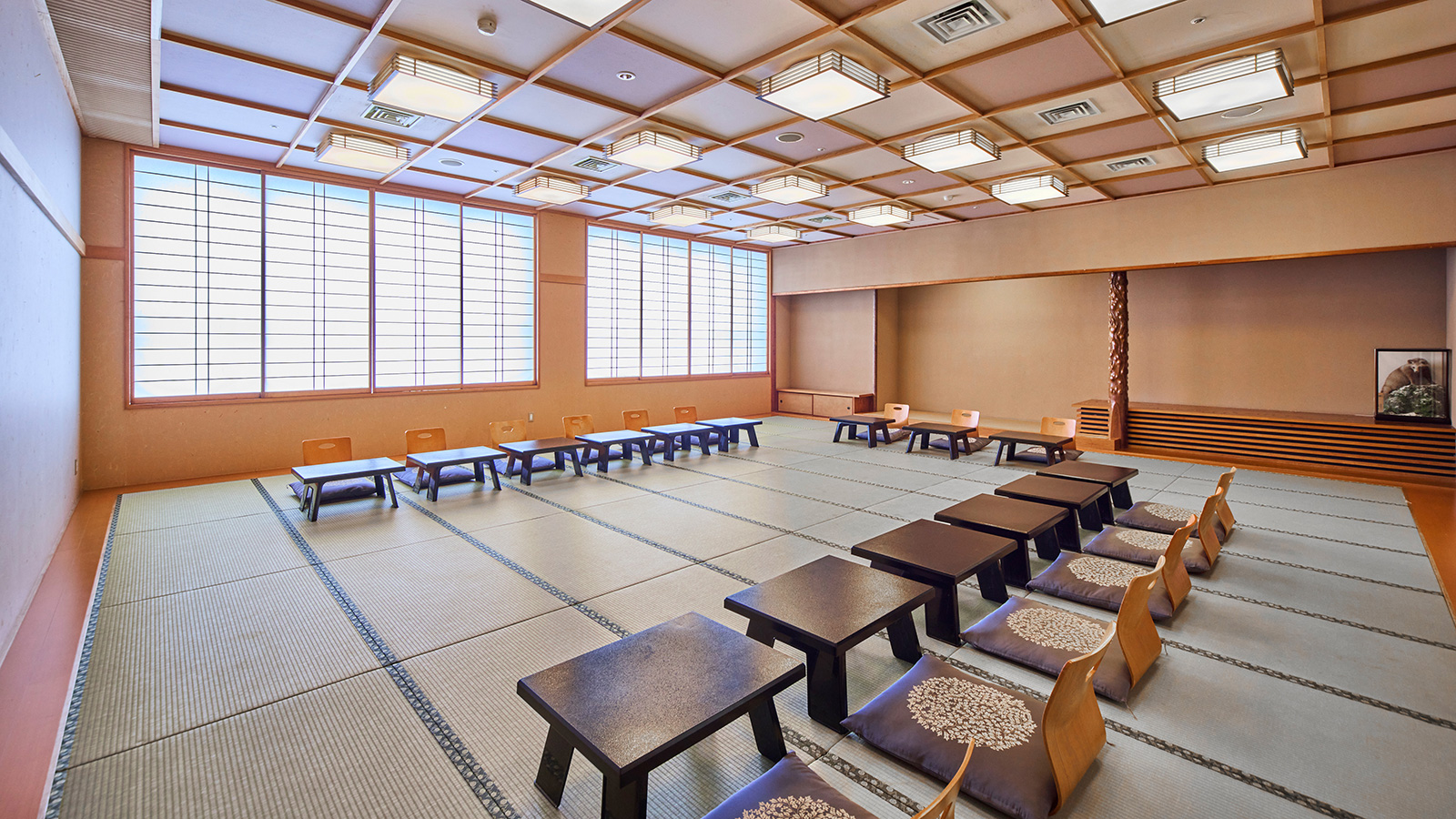 明るい日差しの昼の菊の間・座椅子と一人ずつのお膳を並べた宴会に最適な畳の部屋