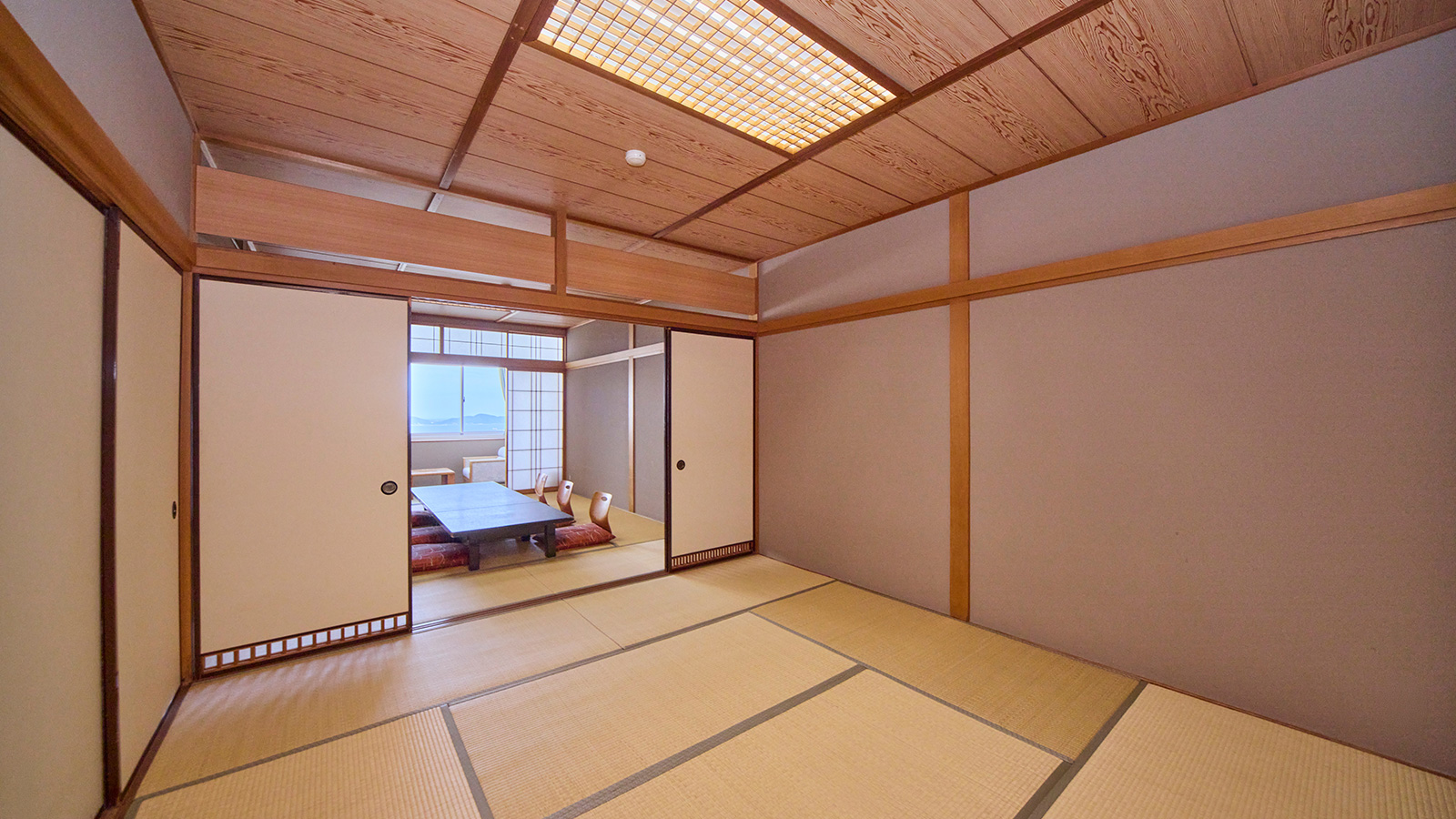和室18畳・襖で仕切れる二間続きの広い畳の部屋を少し斜めから見た構図