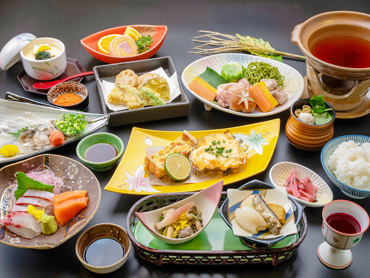 長門湯本温泉の旅館、湯本観光ホテル西京の華会席。ふぐの叩き、ふぐと長州どりの茶そば味鍋、ベーコンパプリカキッシュと旬魚の曙焼きなど、10品の料理が並ぶ。