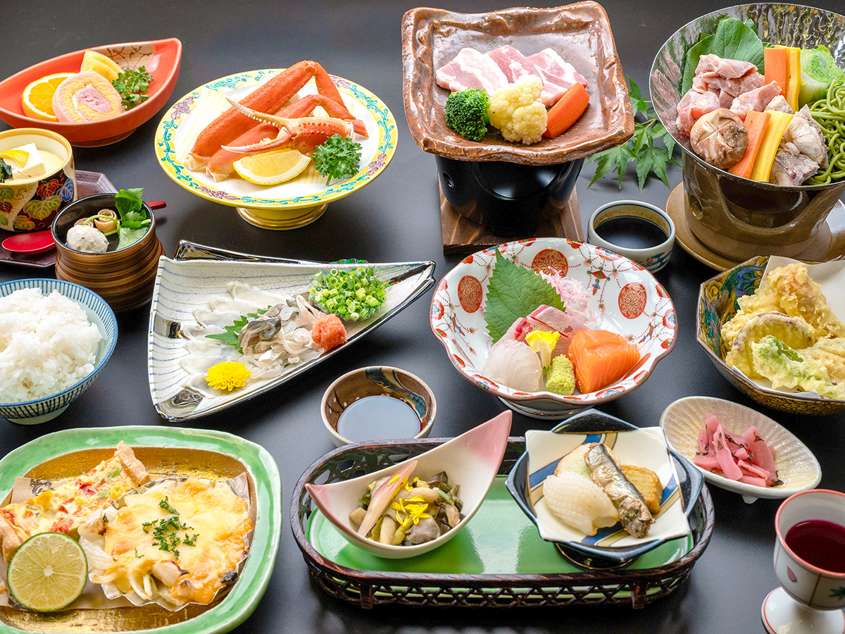 長門湯本温泉の旅館、湯本観光ホテル西京の薫会席。ふぐの叩き、豚陶板焼き、ズワイガニ酢など、12品の料理が並ぶ。